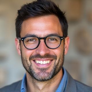 Ritratto professionale di Marco Rossi, un uomo con occhiali e un sorriso cordiale.